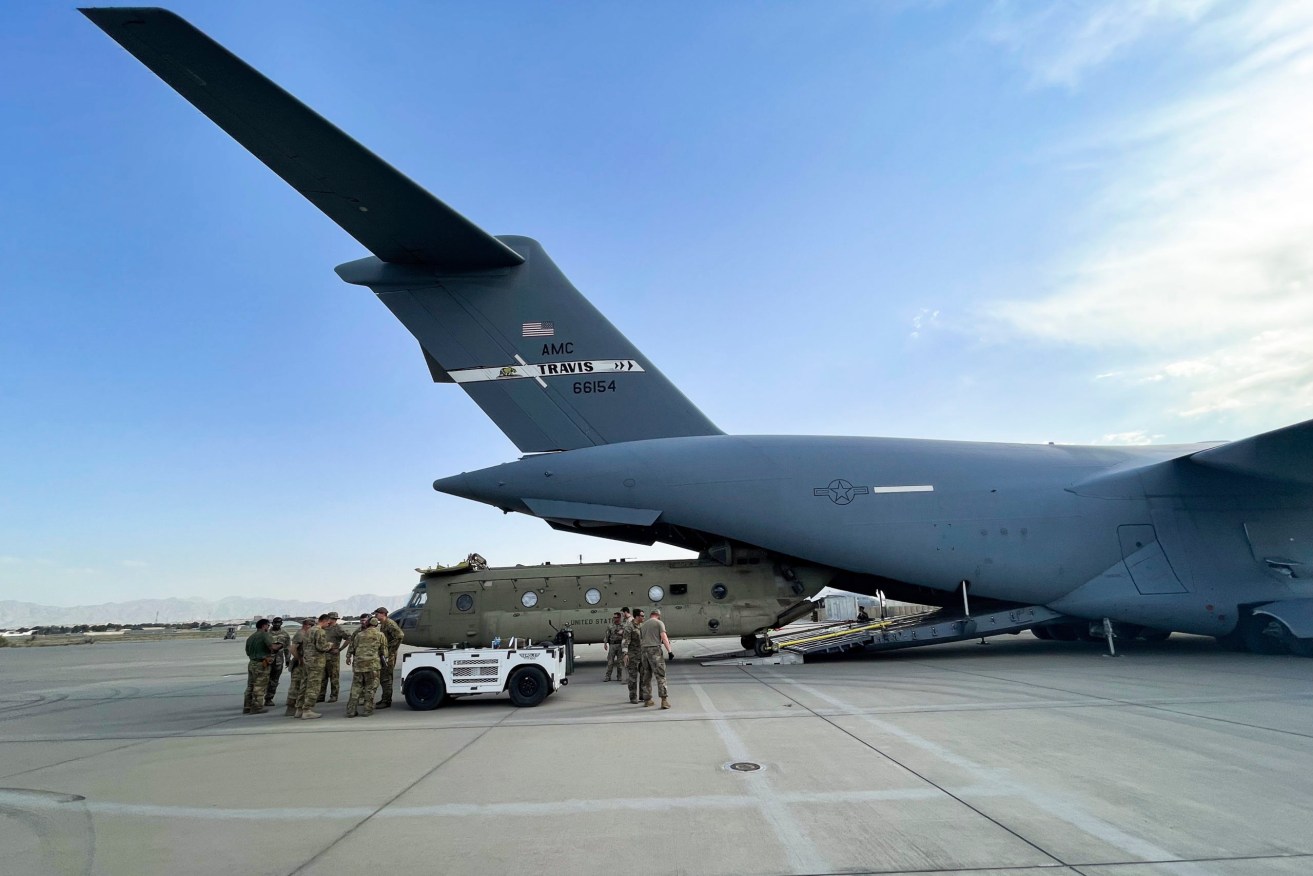 A CH-47 Chinook from the 82nd Combat Aviation Brigade Airborne Division is loaded onto a U.S. Air Force C-17 Globemaster III at Hamid Karzai International Airport in Kabul, Afghanistan, as America completes its 20-year war in the strife-torn nation. (Department of Defense via AP)