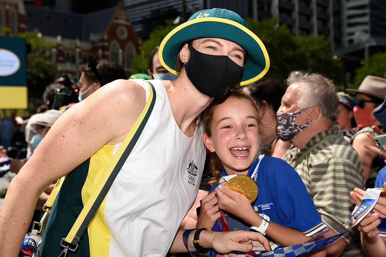 Australian swimmer Cate Campbell takes photos with fans during Friday's welcome home parade for Queensland’s Tokyo 2021 Olympians and Paralympians(AAP Image/Albert Perez) 