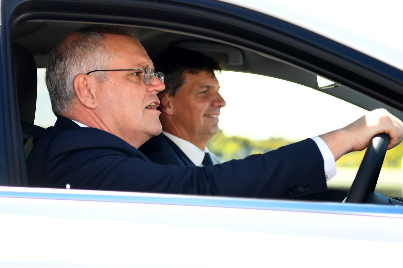 Prime Minister Scott Morrison (left) and Minister for Energy and Emissions Reduction Angus Taylor drive a hydrogen-fuelled car around a Toyota test track in Melbourne. (AAP Image/Pool, William West) 