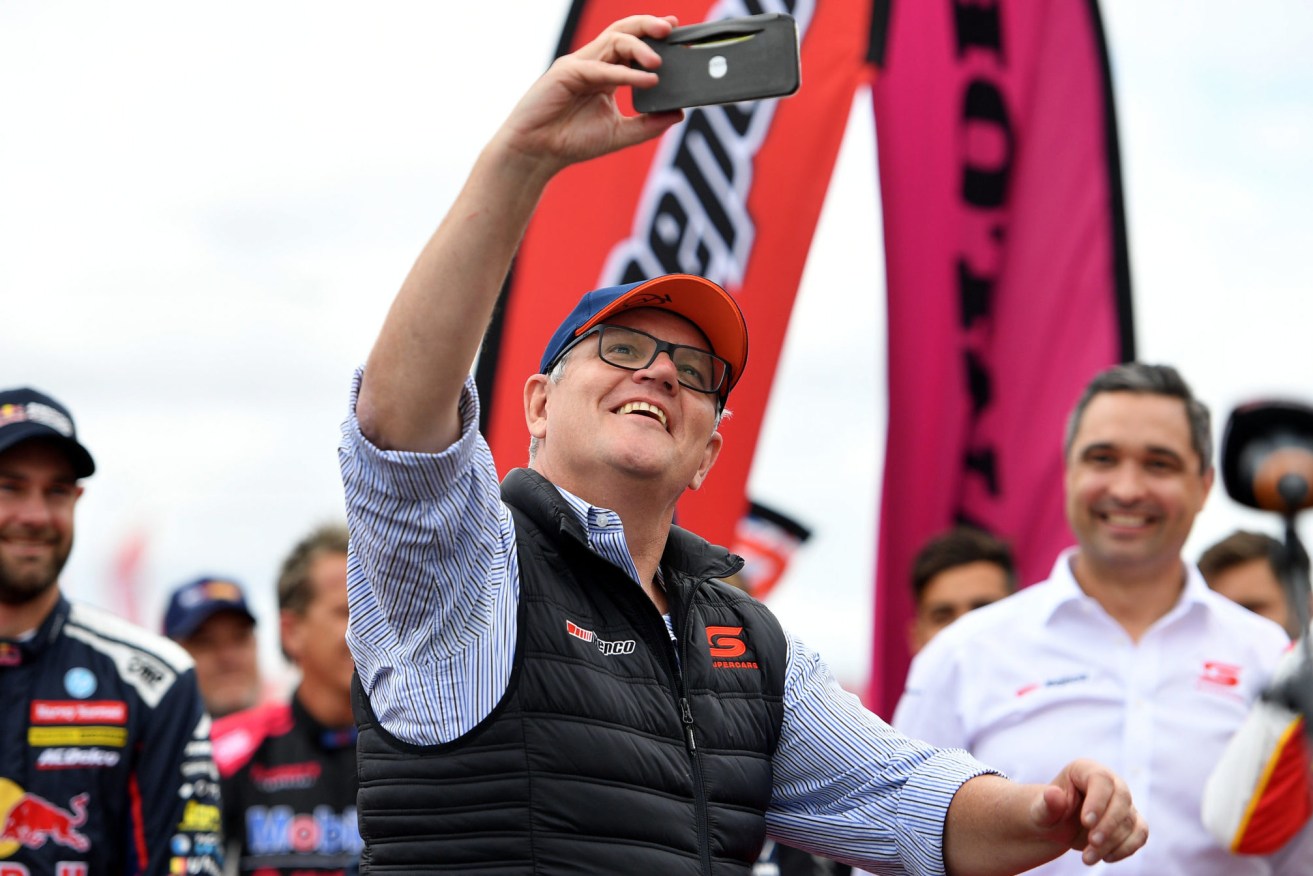 Prime Minister Scott Morrison takes a selfie with drivers on the grid ahead of the 2021 Supercars Championship Bathurst 1000 at Mount Panorama, in Bathurst, NSW, Sunday, December 5, 2021. (AAP Image/Dan Himbrechts) 