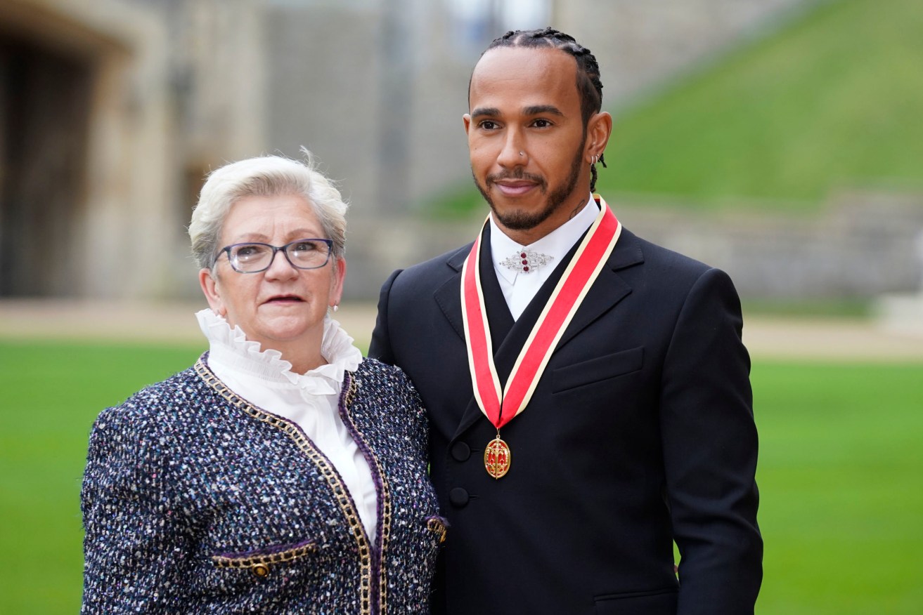 Lewis Hamilton with his mother Carmen Lockhart poses for the media after he was made a Knight Bachelor by Britain's Prince Charles during a investiture ceremony at Windsor Castle. (Andrew Matthews/Pool Photo via AP)