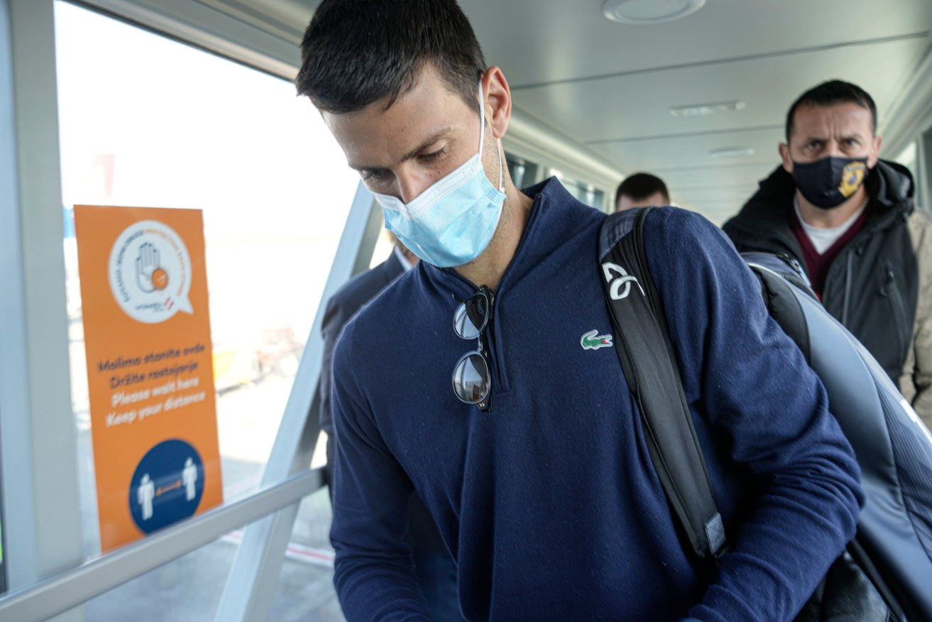 Novak Djokovic looks as his documents after landing in Belgrade, Serbia, Monday. Djokovic arrived in the Serbian capital following his deportation from Australia on Sunday after losing a bid to stay in the country to defend his Australian Open title despite not being vaccinated against COVID-19.(AP Photo/Darko Bandic)