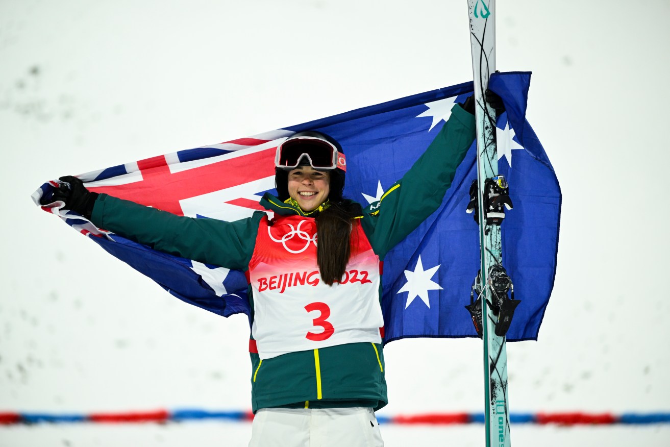 Jakara Anthony of Australia celebrates holding the Australian flag after winning gold in the Women’s Freestyle Skiing Moguls Finals round during the 2022 Beijing Winter Olympic Games (AAP Image/Dan Himbrechts) 