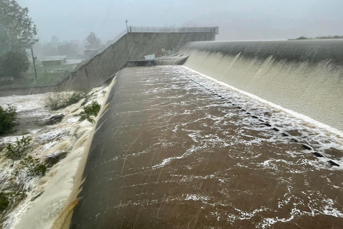 Water rushes over the Enoggera Dam spillway on Sunday.