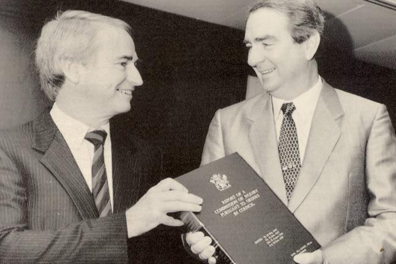 Commissioner Tony Fitzgerald presents his report of the Royal Commission to then-Premier Mike Ahern. (File image)