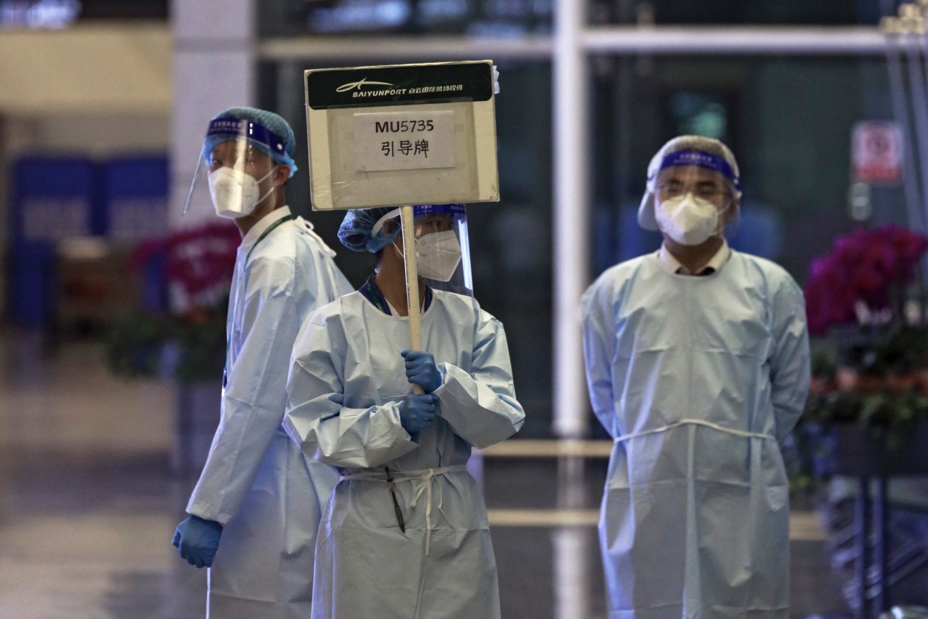 A worker from the China Eastern holds a signboard waiting to lead relatives of the victims aboard China Eastern's flight MU5735 to a cordoned off area in Guangzhou Baiyun International Airport. (Chinatopix Via AP)