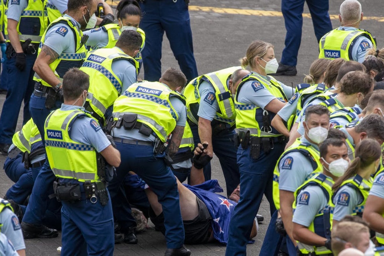 Police confront protesters outside Parliament House in Wellington. (Image: ABC)