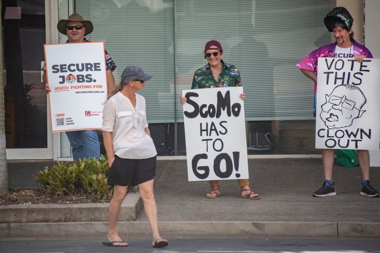 Protesters are seen outside an event attended by Prime Minister Scott Morrison in Cairns, Tuesday (AAP Image/Brian Cassey) 