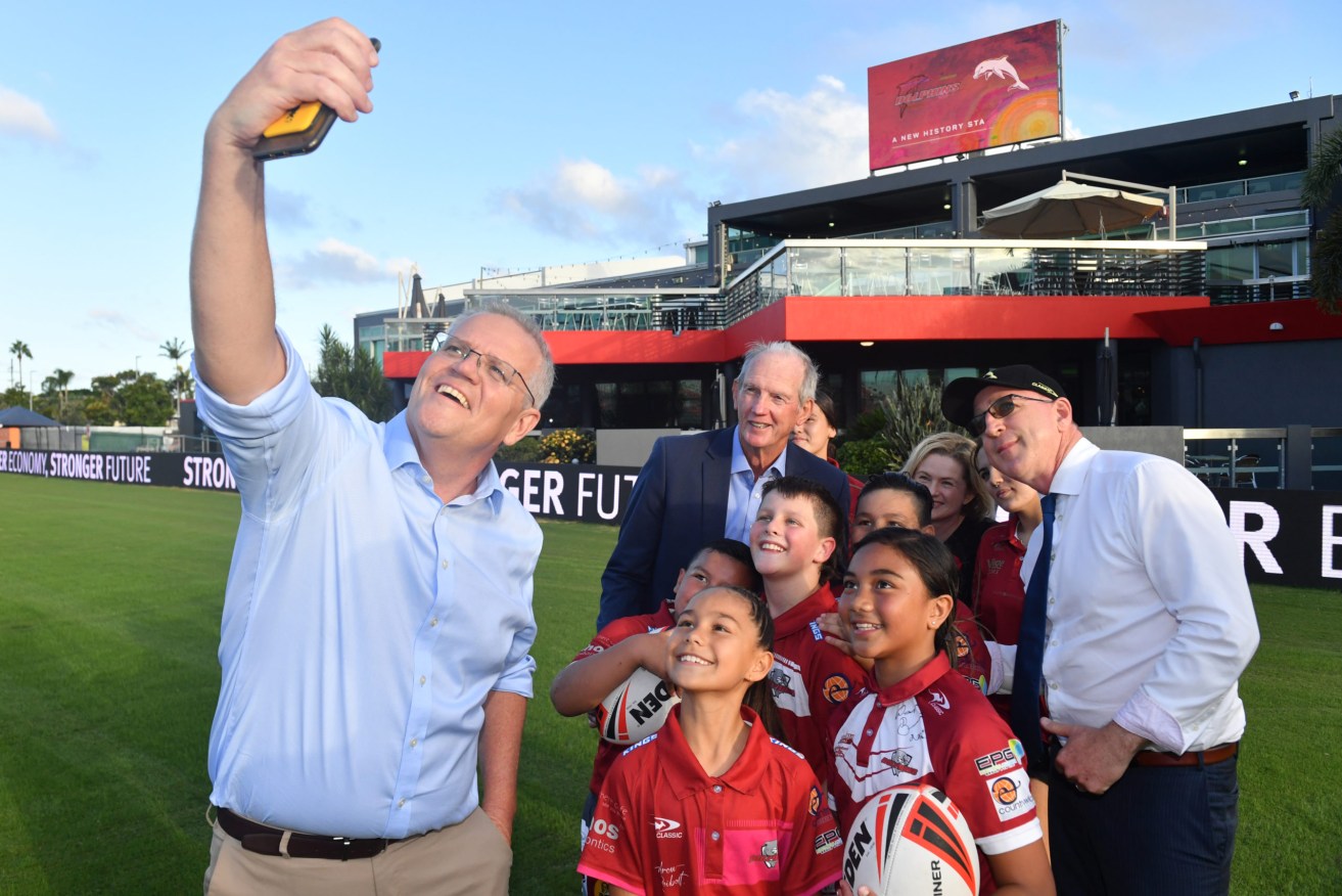 Prime Minister Scott Morrison takes a selfie at Redcliffe Dolphins Stadium in Redcliffe. He says the "new" attitude is nothing to do with opinion polling.. . (AAP Image/Mick Tsikas) 