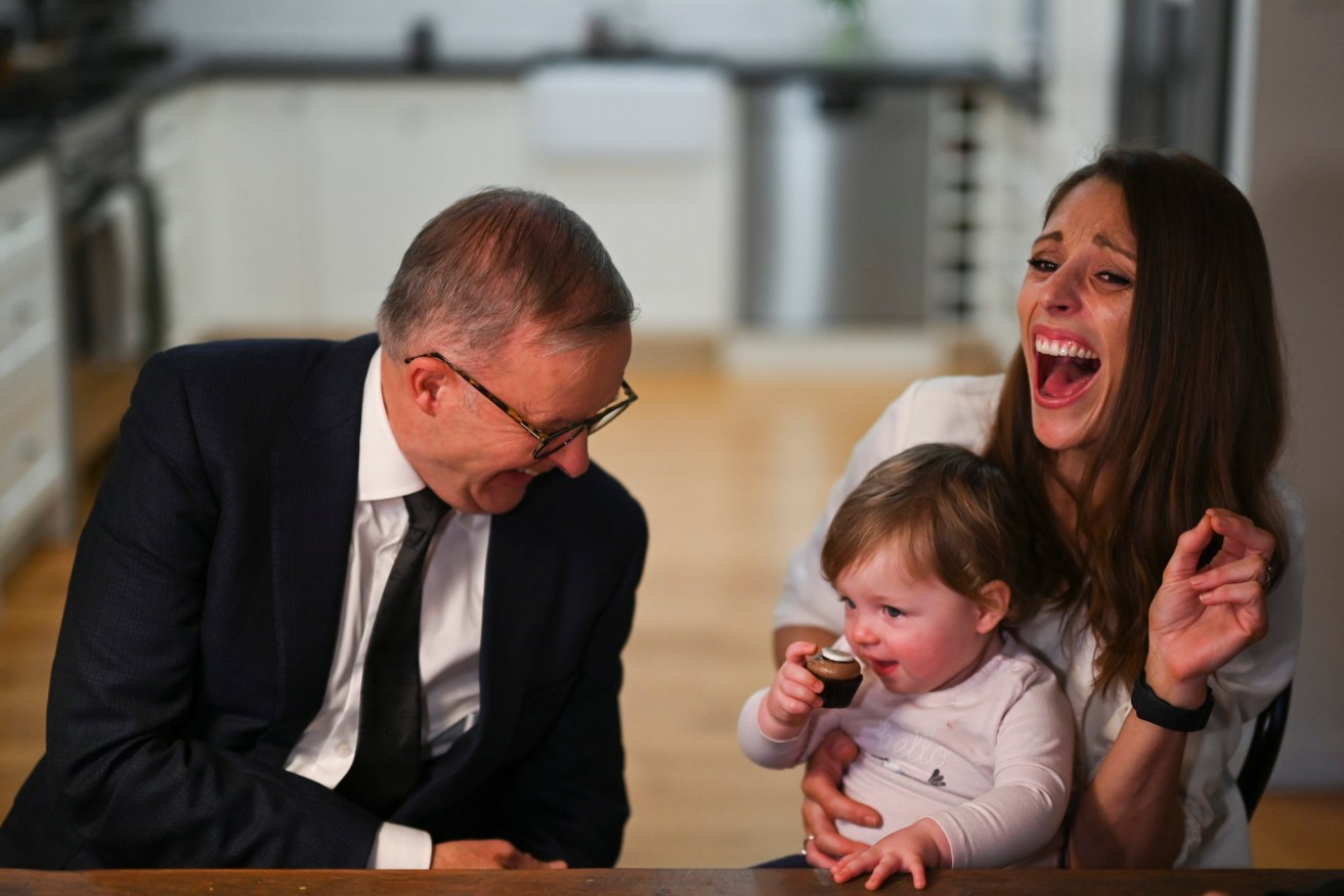 Opposition Leader Anthony Albanese is offered a cupcake by little girl Isla as he speaks to parents during a meeting with an advocacy group in Sydney. (AAP Image/Lukas Coch)