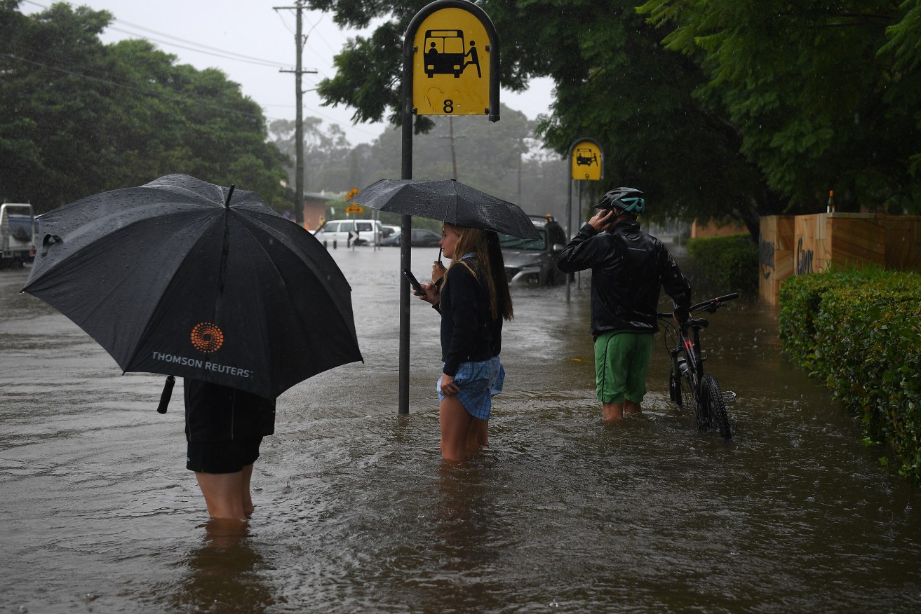 Flooding from a swollen Manly Creek is seen inundating cars and the street at Campbell Parade, in Manly Vale, north of Sydney, Tuesday, March 8, 2022. Manly Dam in Sydney's north is spilling over and residents are being urged to flee with 800 homes at risk of flooding. (AAP Image/Dan Himbrechts) NO ARCHIVING