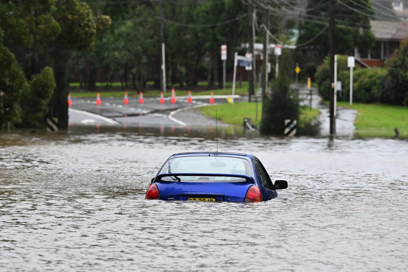 An abandoned car in floodwaters in Lansvale in Western Sydney. (AAP Image/Mick Tsikas) 
