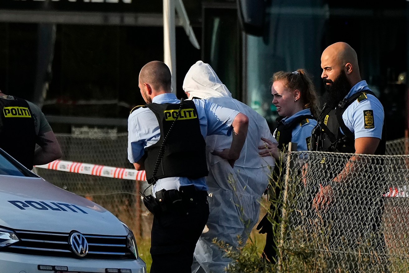A person in a white DNA suit is taken away by the police, near the Field's shopping center, after a shooting, in Copenhagen, Denmark. (Claus Bech/Ritzau Scanpix via AP)
