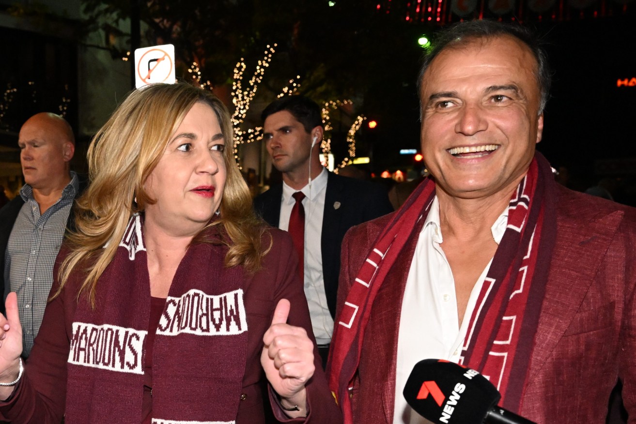  Premier Annastacia Palaszczuk (centre) and her partner Dr Reza Adib (right) walk down Caxton Street before Game 3 of the 2022 State of Origin series between the New South Wales Blues and the Queensland Maroons at Suncorp Stadium.  (AAP Image/Darren England)