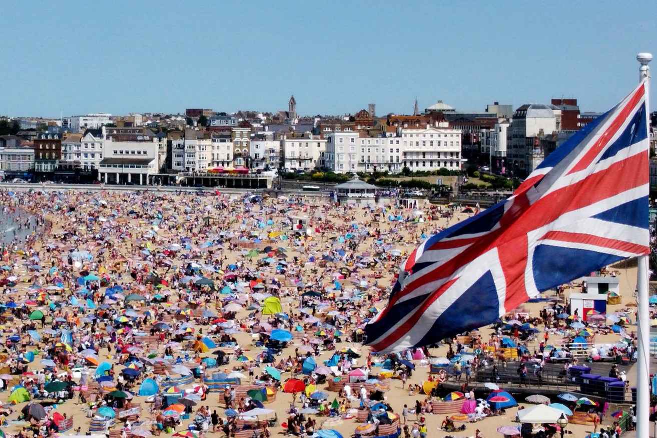 A view of people on the beach in Margate, Kent, England, Sunday, July 17, 2022. The Met office has issued its first-ever “red warning” of extreme heat for Monday and Tuesday, when temperatures in southern England may reach 40 C (104 F) for the first time. (Gareth Fuller/PA via AP)