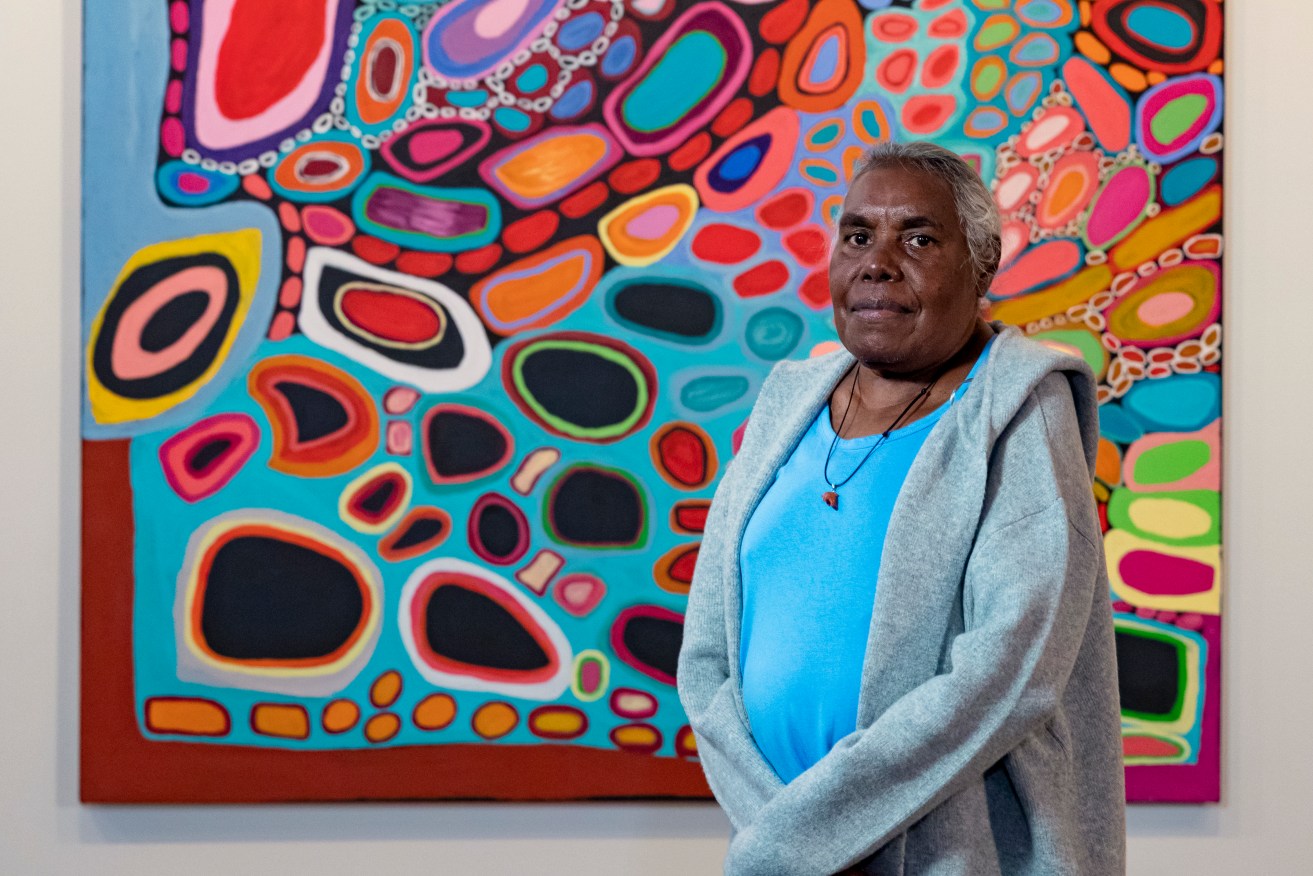 Mornington Island artist Dorothy Gabori with Our Mother’s and Grandmother’s Country, which she created with Amanda Jane Gabori, at The National Museum, Canberra. (AAP Image/Supplied by The National Museum, Jason McCarthy) 