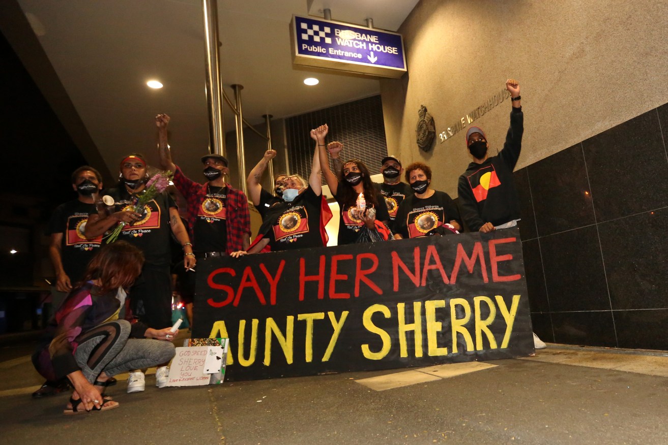 Family of Aunty Sherry Tilberoo outside the Brisbane Watch House during a vigil to mourn her death. (AAP Image/Danny Casey)