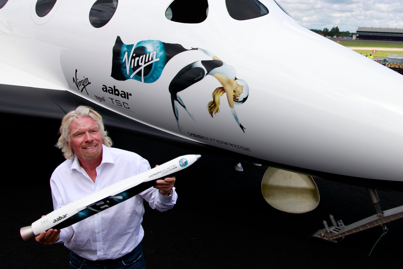  British billionaire Richard Branson holds a model of LauncherOne, a rocket that will be used to launch small satellites into space, at the Farnborough International Airshow in Farnborough, England.  (AP Photo/Lefteris Pitarakis,File)