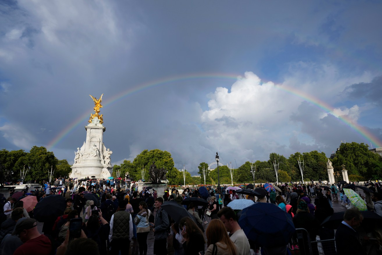 People gather outside Buckingham Palace in London as a double rainbow appeared in the sky while the Queen neared death at Balmoral. (AP Photo/Frank Augstein)