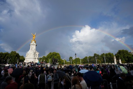 Rainbows, silence before crowds sing God Save the Queen near palace