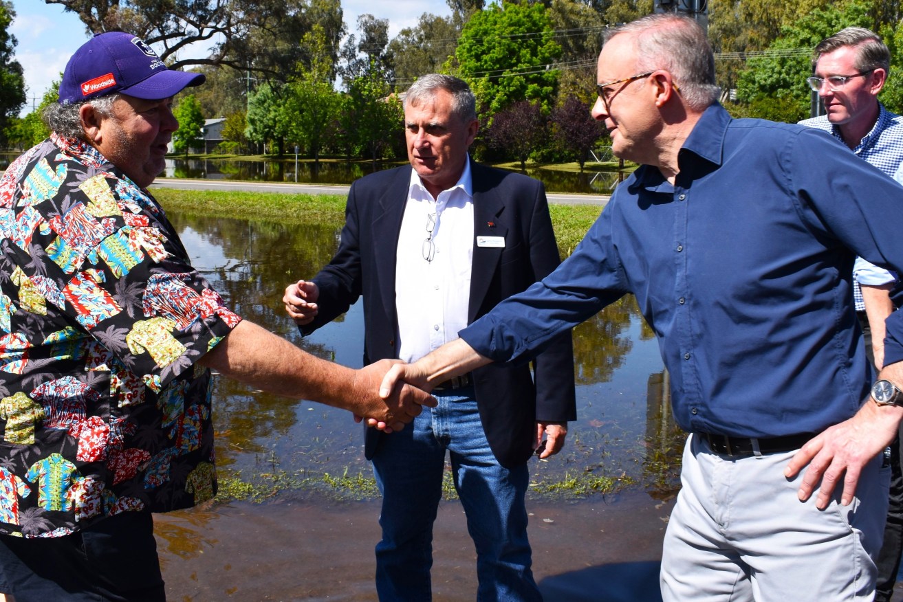 Forbes resident Grahame Ruge greets Australian Prime Minister Anthony Albanese (centre) and New South Wales Premier Dominic Perrottet (second right) during a tour to flood affected areas in Forbes, in the Central West region of New South Wales. (AAP Image/Murray McCloskey) 