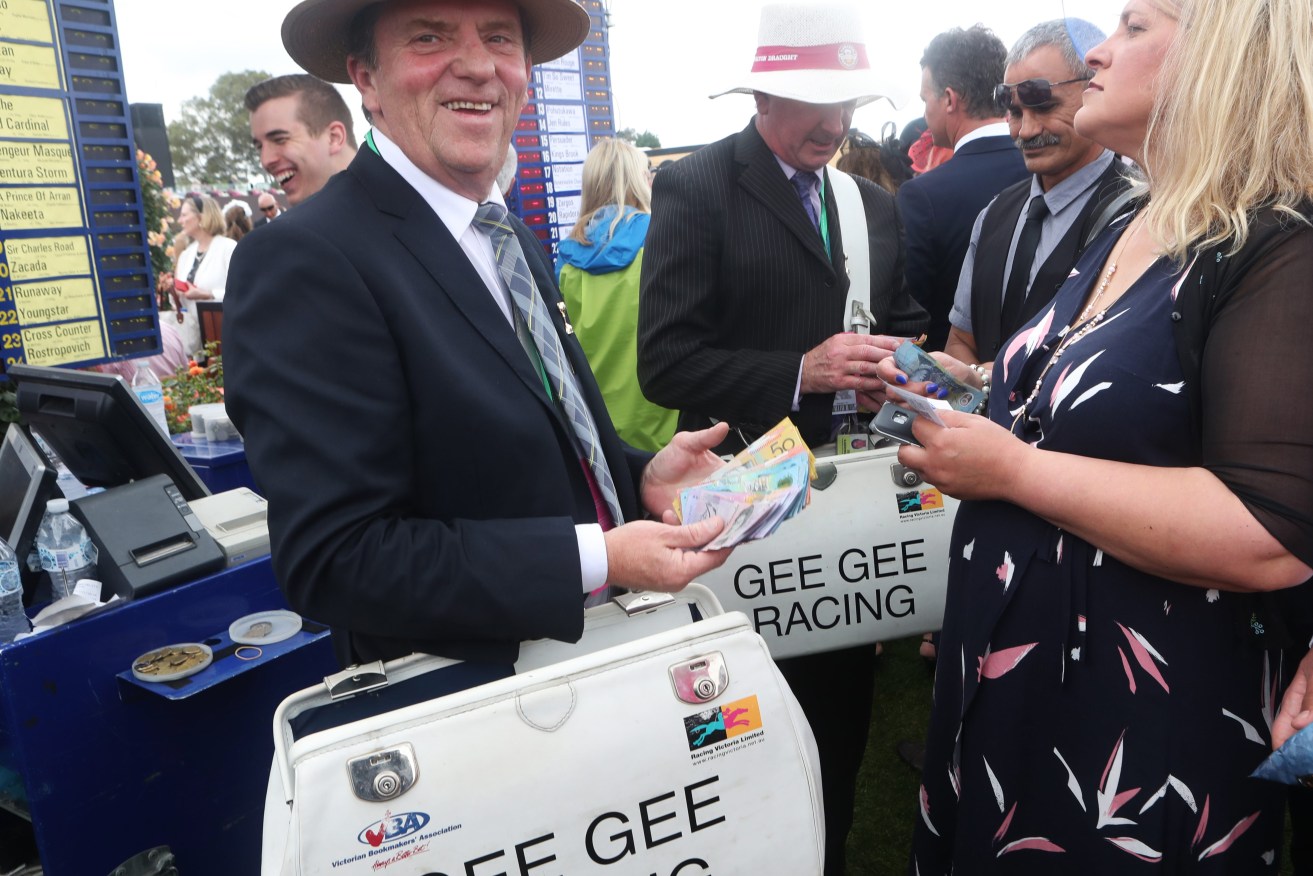 Racegoers place bets during Melbourne Cup Day, as part of the Melbourne Cup Carnival, at Flemington Racecourse in Melbourne, (AAP Image/Dave Crosling) 