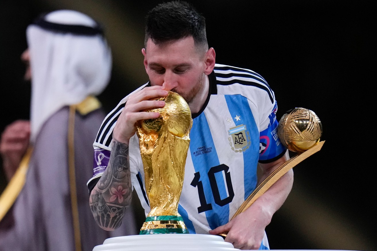 Argentina's Lionel Messi kisses the trophy as he holds the Golden Ball award for best player of the tournament after winning the World Cup final soccer match between Argentina and France at the Lusail Stadium in Lusail, Qatar (AP Photo/Manu Fernandez)