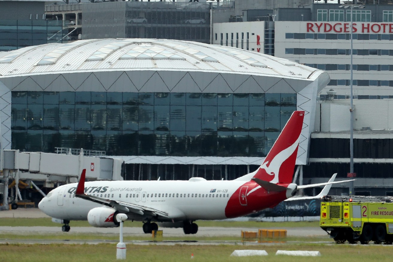 QF144 lands as emergency crews follow at Sydney International Airport in Sydney  after issuing a mayday call as it travelled from Auckland, with emergency services rushing to the aircraft. (AAP Image/Jeremy Ng) 