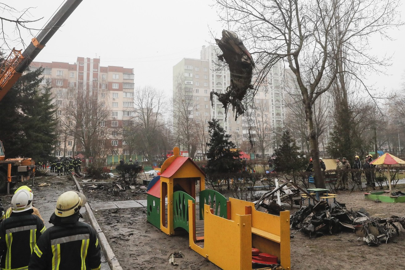 Rescue services remove debris of the helicopter at the scene of a helicopter crash in Brovary, near Kyiv. (Image: EPA/SERGEY DOLZHENKO)