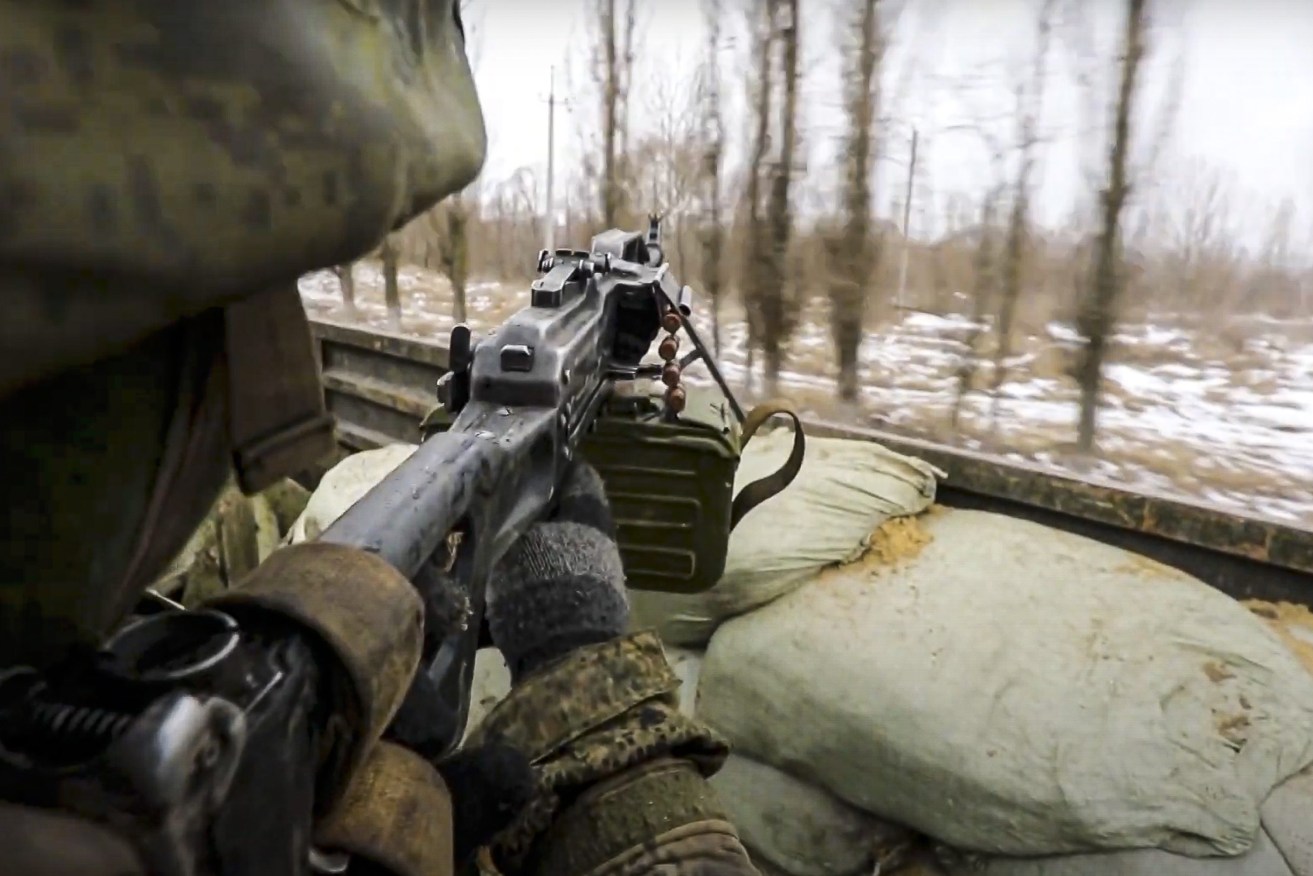 In this photo taken from video released by the Russian Defense Ministry Press Service, a Russian soldier points a gun from a Russian military truck as it drives through an undisclosed location in Ukraine. (Russian Defense Ministry Press Service via AP)