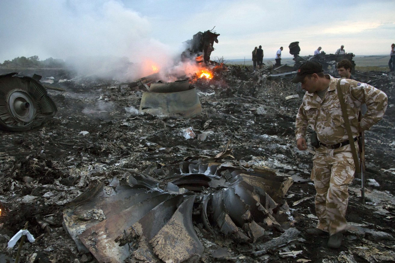  People walk amongst the debris at the crash site of a passenger plane near the village of Grabovo, Ukraine, July 17, 2014. An international team is presenting an update Wednesday Feb. 8, 2023 on its investigation into the 2014 downing of Malaysia Airlines flight MH17 over eastern Ukraine. (AP Photo/Dmitry Lovetsky, File)