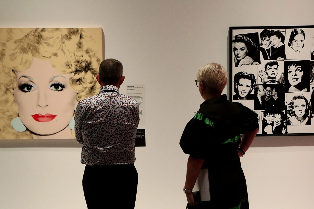 People look at art by Andy Warhol during the world premiere exhibition, Pop Masters: Art from the Mugrabi Collection, New York at HOTA, Gold Coast, Thursday, February 16, 2023. (AAP Image/Jason O'Brien) 