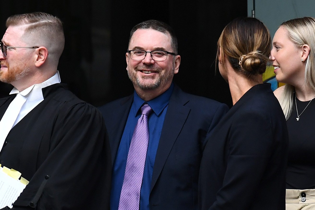 Former Logan City Council Mayor Luke Smith (middle) arrives to the Brisbane District Court t learn his fate. (AAP Image/Jono Searle) 