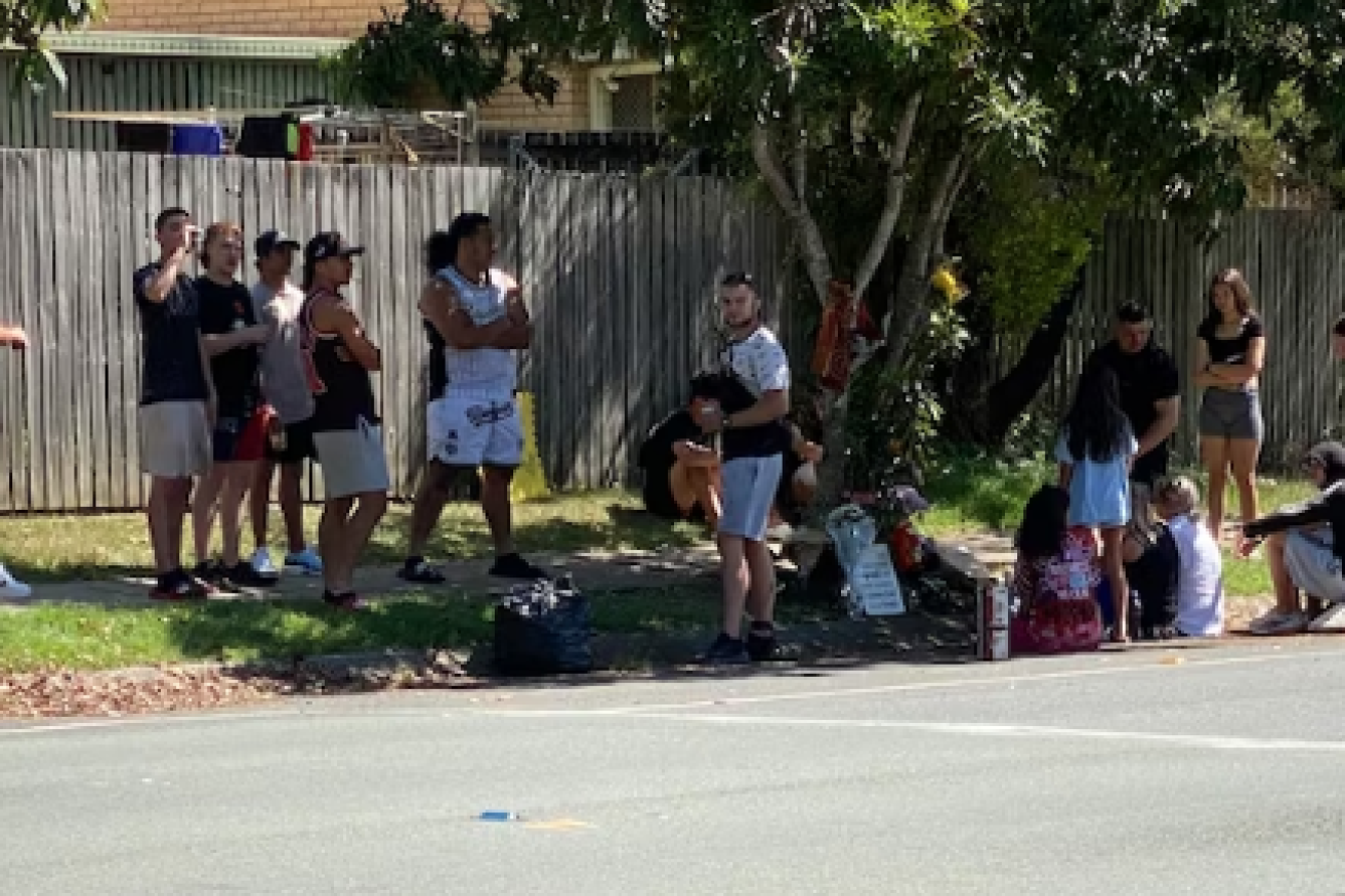 Friends gather at the scene where a 17-year-old dirt bike rider died in an alleged hit-run near Brisbane. (Image ABC).