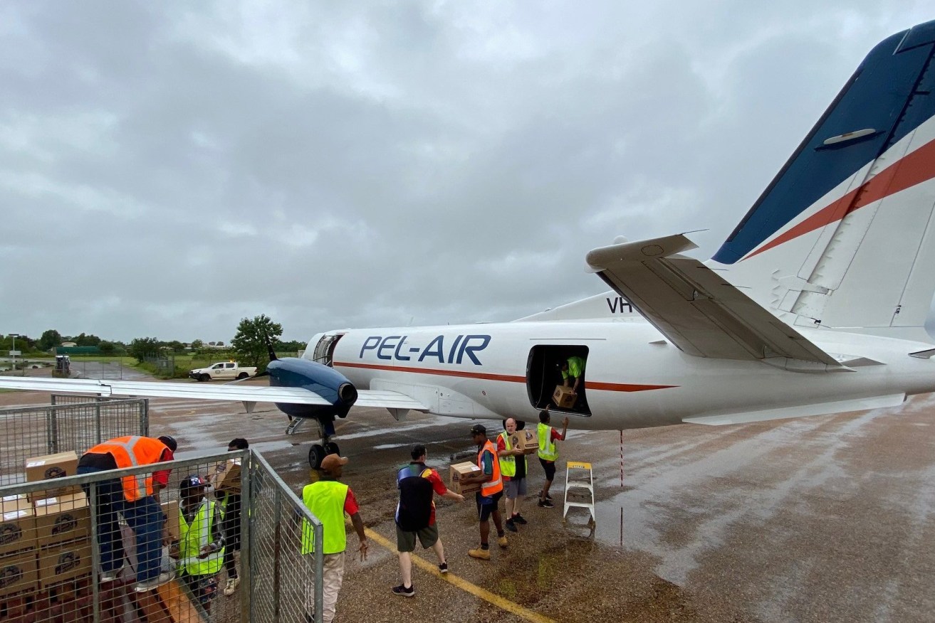 Essential supplies for the stranded community of Doomadgee landed from Cairns with heavy rain continuing to fall over saturated north-west Queensland. (Image: QFES)