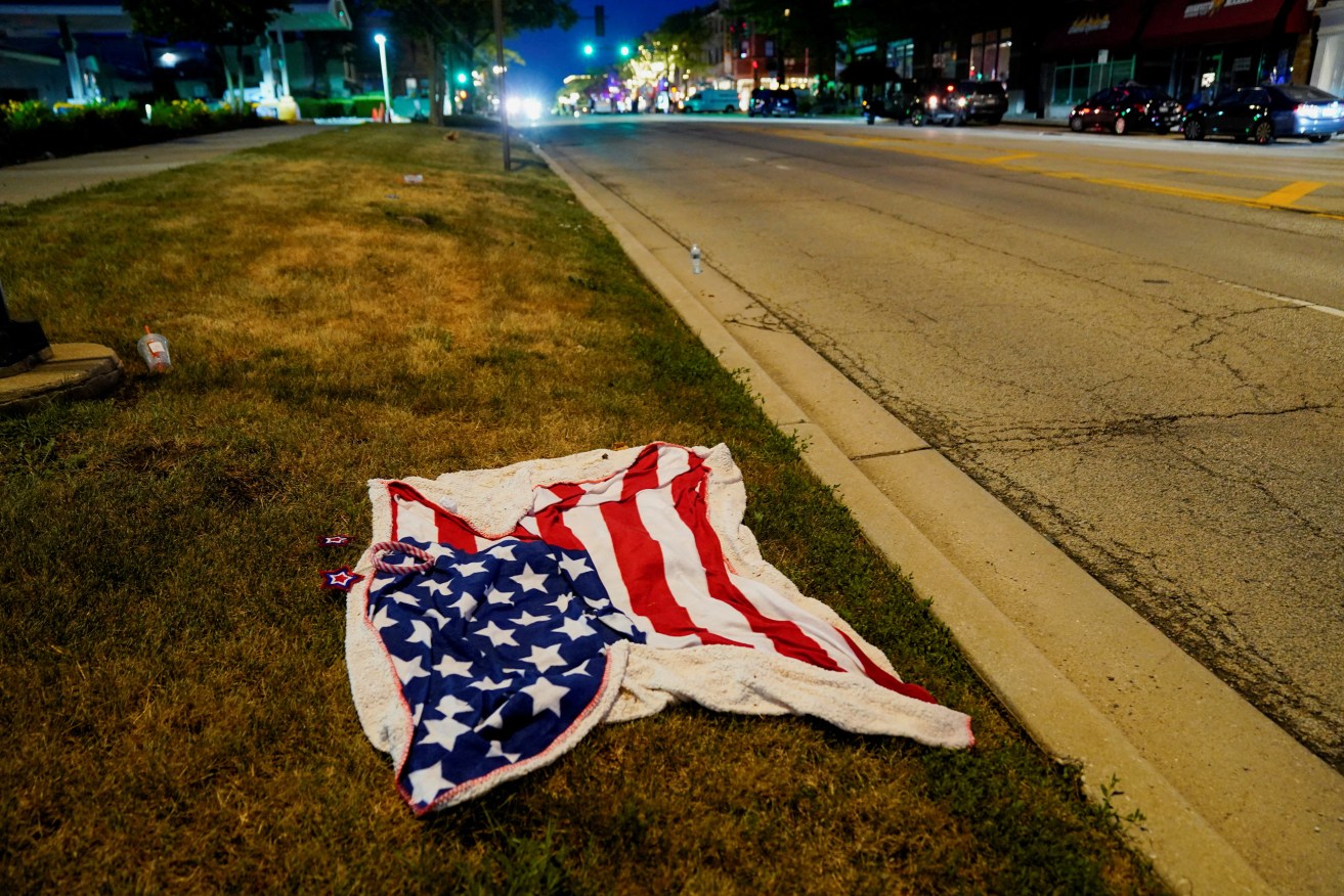 An American flag blanket is seen abandoned along the parade route after a mass shooting at a Fourth of July parade in the Chicago suburb of Highland Park, Illinois.  REUTERS/Cheney Orr     TPX