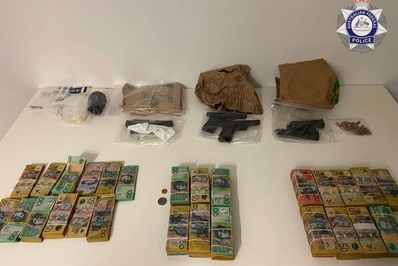 A supplied undated image obtained Friday, April 28, 2023 shows two handguns, ammunition, $370,000 cash and methamphetamine seized by the Australian Federal Police in Brisbane. An alleged bikie stands accused of trying to hide  the items before running from airport security. (AAP Image/Supplied by the Australian Federal Police) 