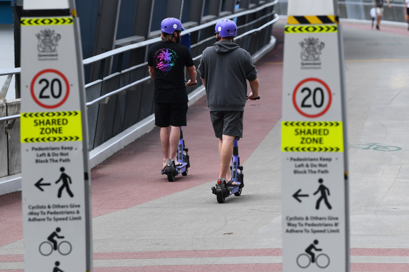 E-scooters are seen being ridden in Brisbane. From Tuesday, fines of up to $1078 will apply to e-scooter users for breaking Queensland laws for personal mobility devices. (AAP Image/Jono Searle) 