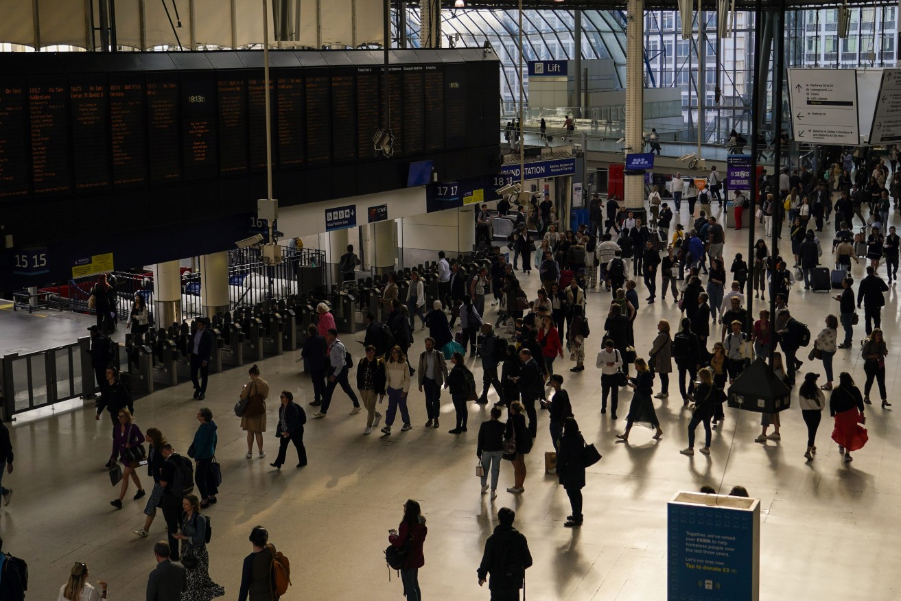 Commuters walk through Waterloo Station, in London, Monday, June 5, 2023. (AP Photo/Alberto Pezzali)