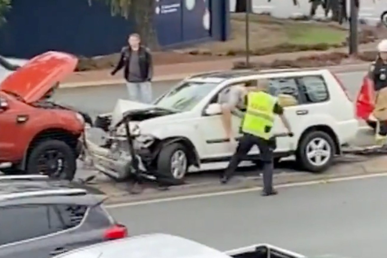 A still image taken from video and obtained on Friday, June 23, 2023, shows a Queensland Police officer striking a man following a three-car crash in Brisbane's north. (AAP Image/Supplied, Nine News) 