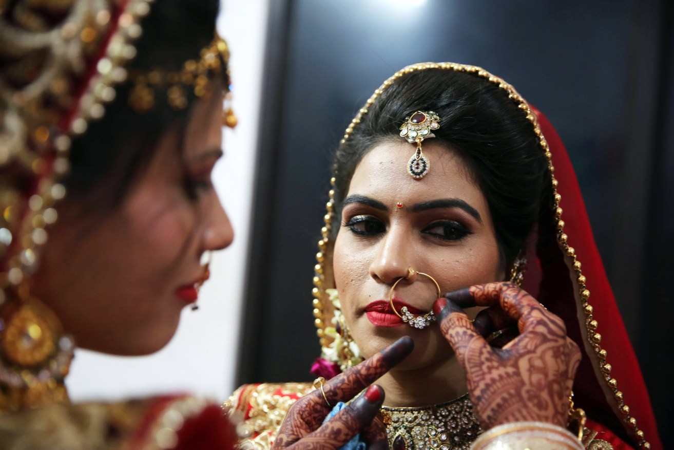 epa05884068 Indian brides of Jain community adjust their jewellery as they take part in a mass marriage ceremony under Mukhyamantri Kanyadan Yojna (chief minister welfare scheme) organized by the Late, Babulal Pradhan Memorial Trust in Bhopal, India, 02 April 2017. More than 15 Jain couples tied up the nuptial knot in the marrriage ceremony.  EPA/SANJEEV GUPTA