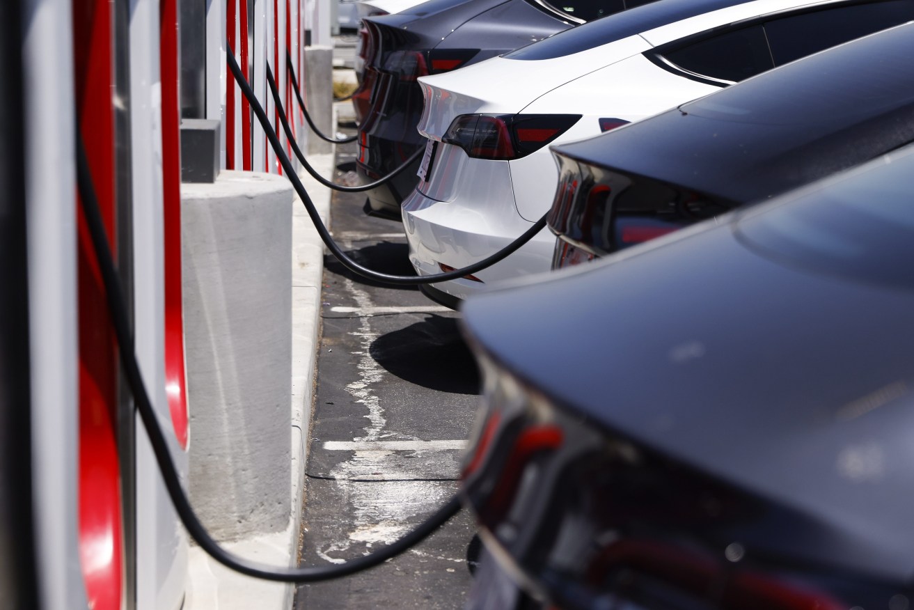 Tesla electric vehicles charge at a supercharger station in Hawthorne, California, (EPA/CAROLINE BREHMAN)