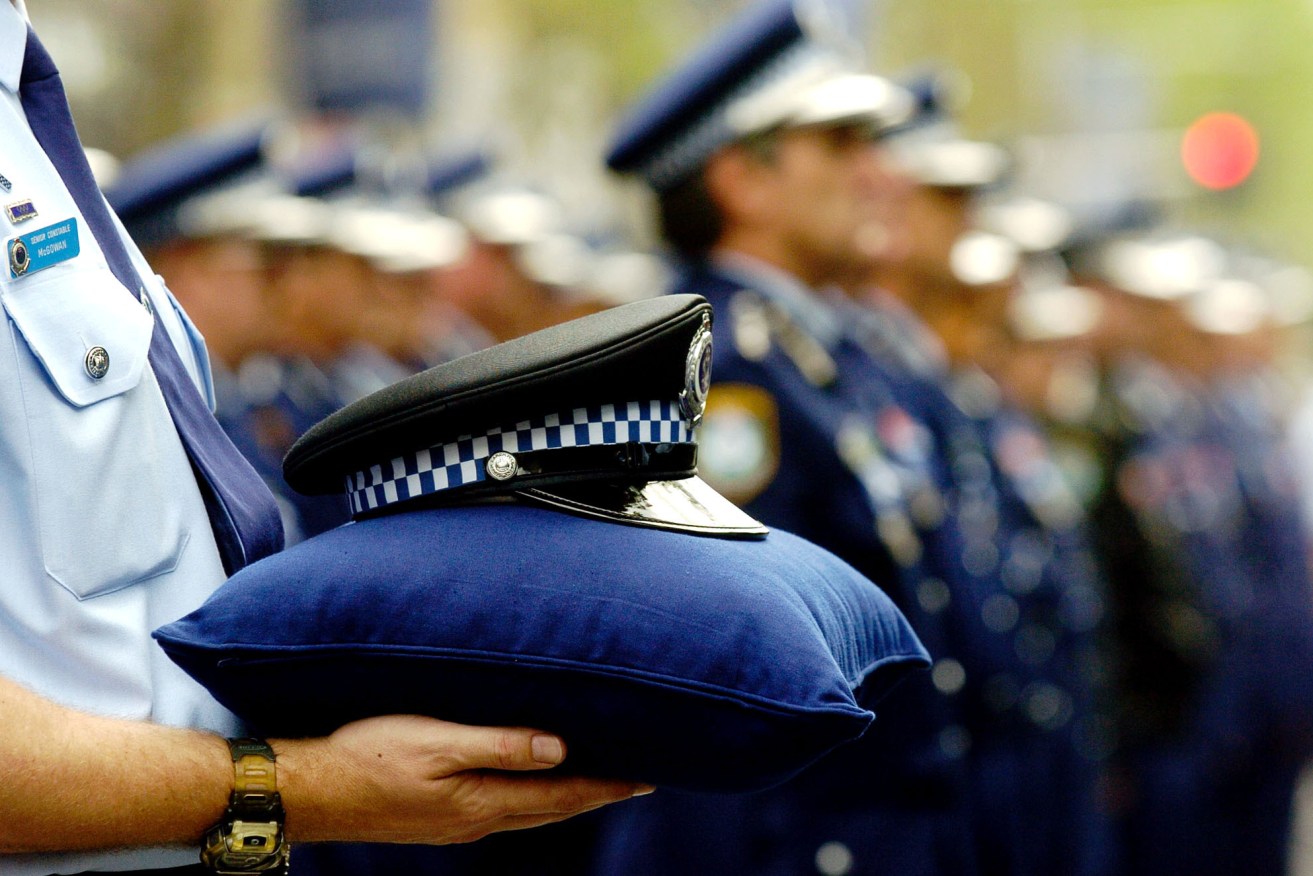 Sydney, September 29, 2004. Police officers stand at attention at Parliment House as an officers hat is held to comemorate the fallan during  National Police Remembrance Day in Sydney today. (AAP Image/Paul Miller) NO ARCHIVING