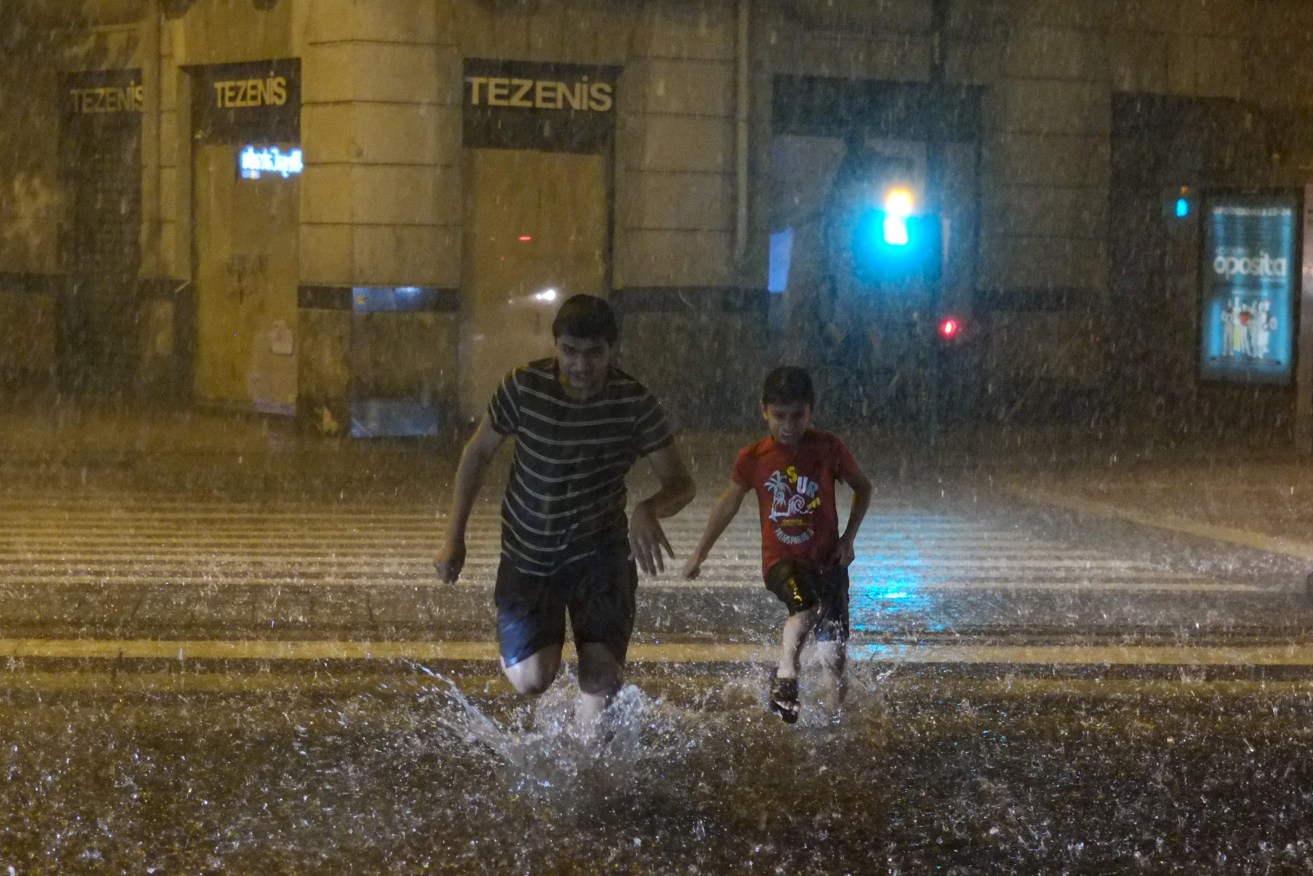 People run across a pedestrian area during heavy rain in Pamplona, northern Spain, Friday, Sept. 1, 2023. Authorities have announced exceptional rainfall for the next few days across the country. (AP Photo/Alvaro Barrientos)