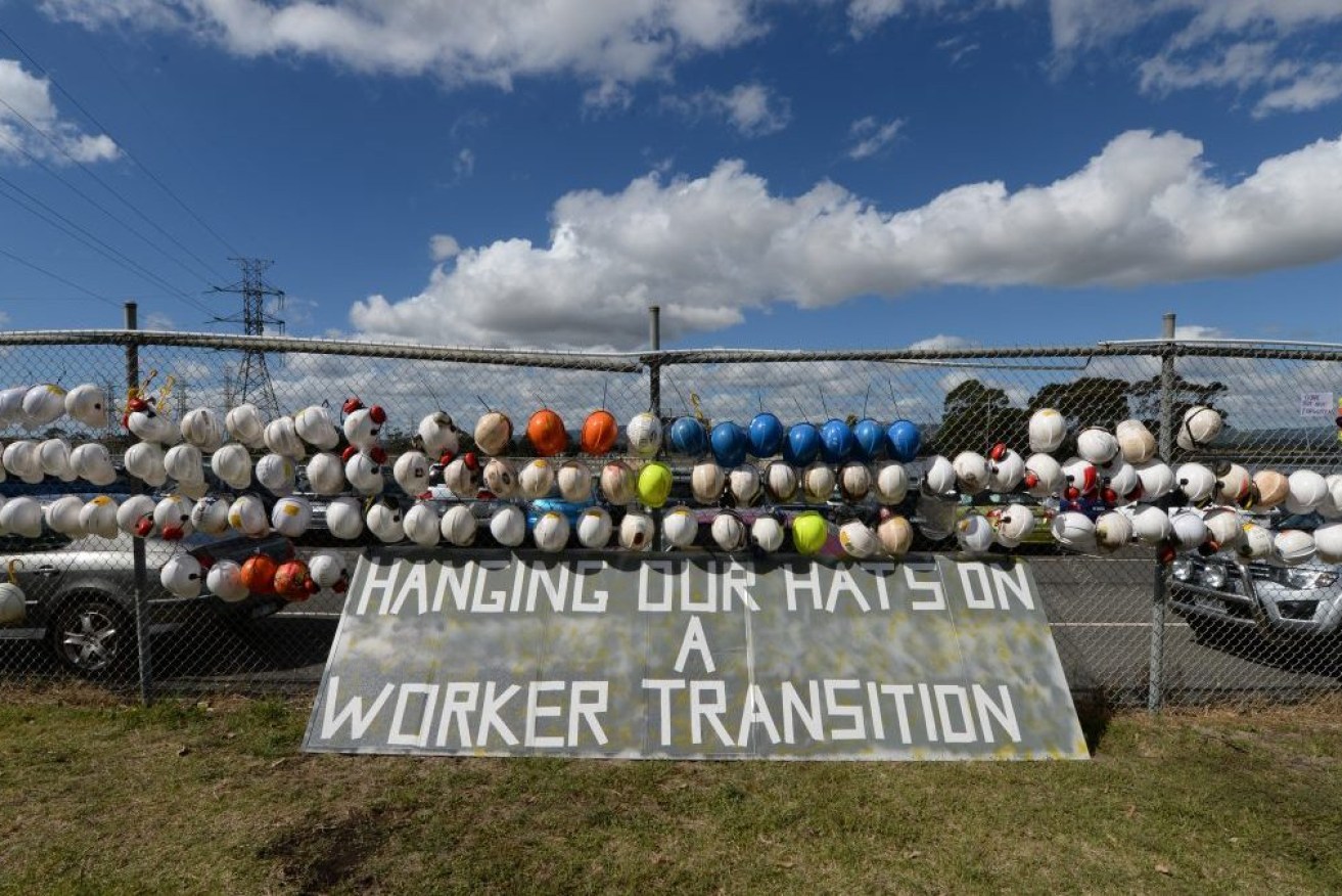 Workers hats hang on the fence outside the Hazelwood power station. 
The Hazelwood coal fired power station in Victoria's La Trobe Valley closes (AAP Image/Mal Fairclough) 