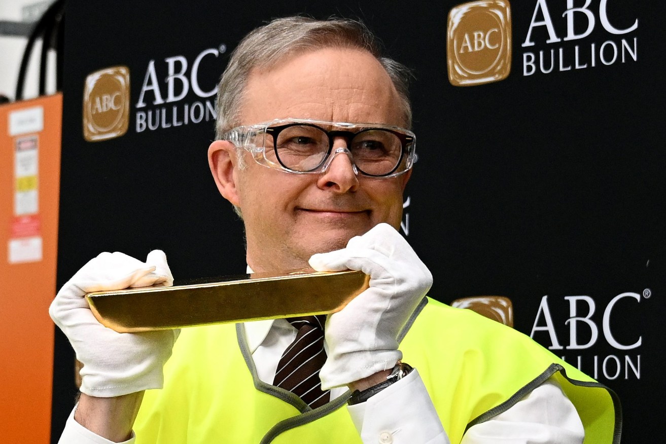 Prime Minister Anthony Albanese lifts gold bullion during a visit with Innovation and Science Minister Ed Husic to Pallion in Marrickville, Sydney. (AAP Image/Dan Himbrechts)