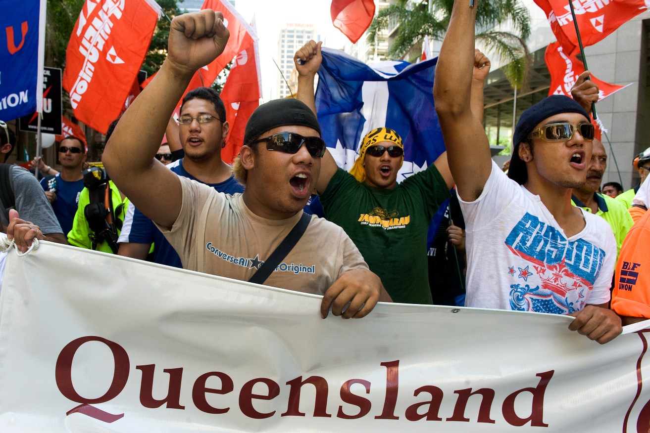 Union members protest through the streets of the Brisbane CBD as they march to Parliament House in Brisbane, (AAP Image/Dave Hunt)