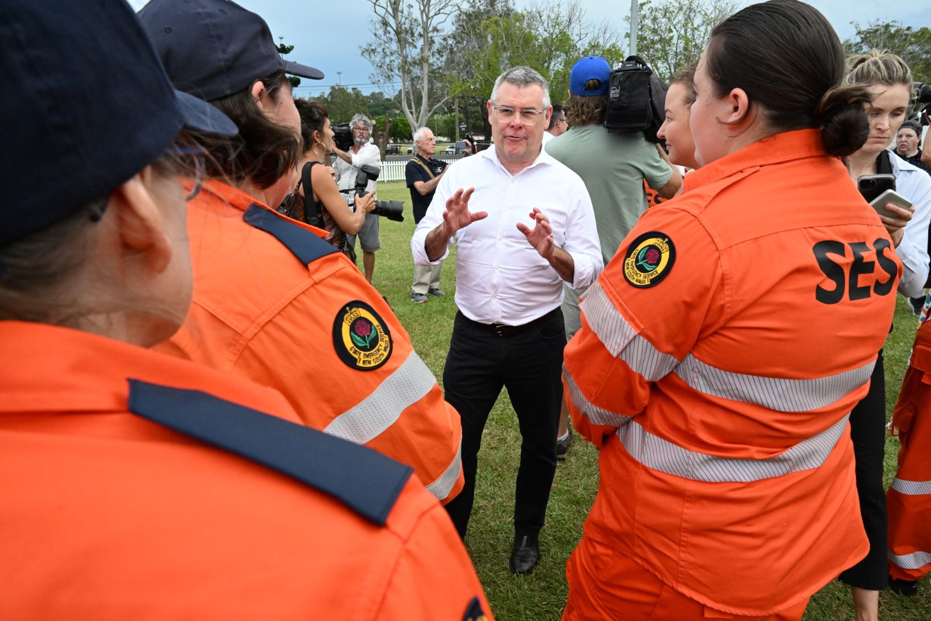 Federal Emergency Management Minister Senator Murray Watt (centre) is seen meeting SES volunteers.  (AAP Image/Darren England) 