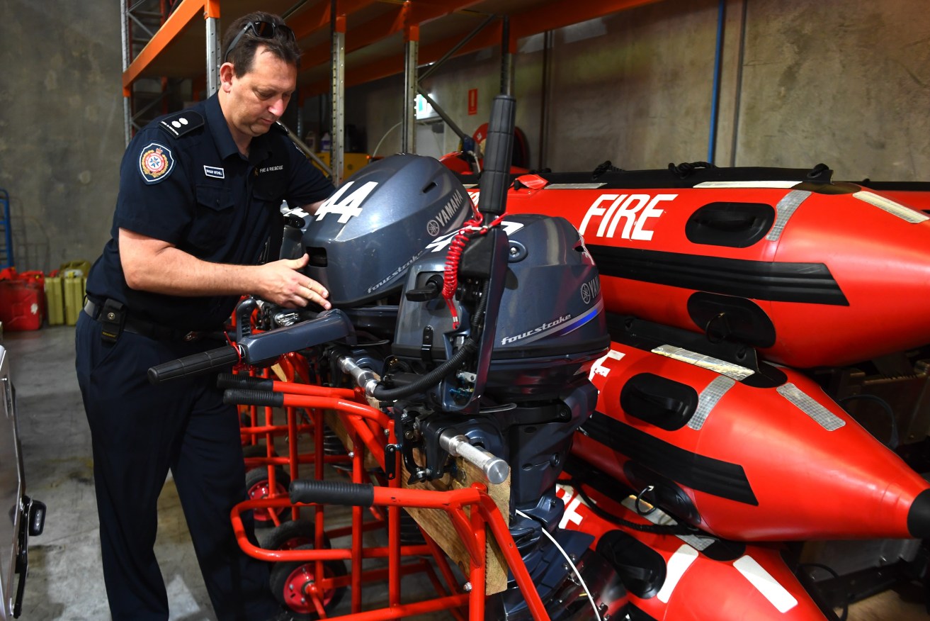 A Fire and Rescue officer prepares swift water rescue boats at a facility in Brisbane. (AAP Image/Jono Searle) 