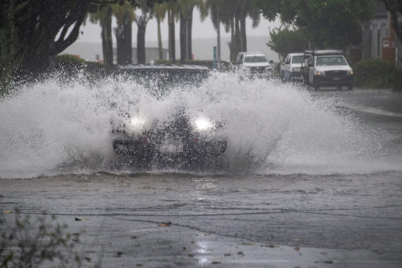 Cars drive through water at the Cairns Esplanade.  People in Tropical Cyclone Jasper's destructive path have been warned they are still not safe despite the system weakening in far north Queensland. (AAP Image/Brian Cassey) 